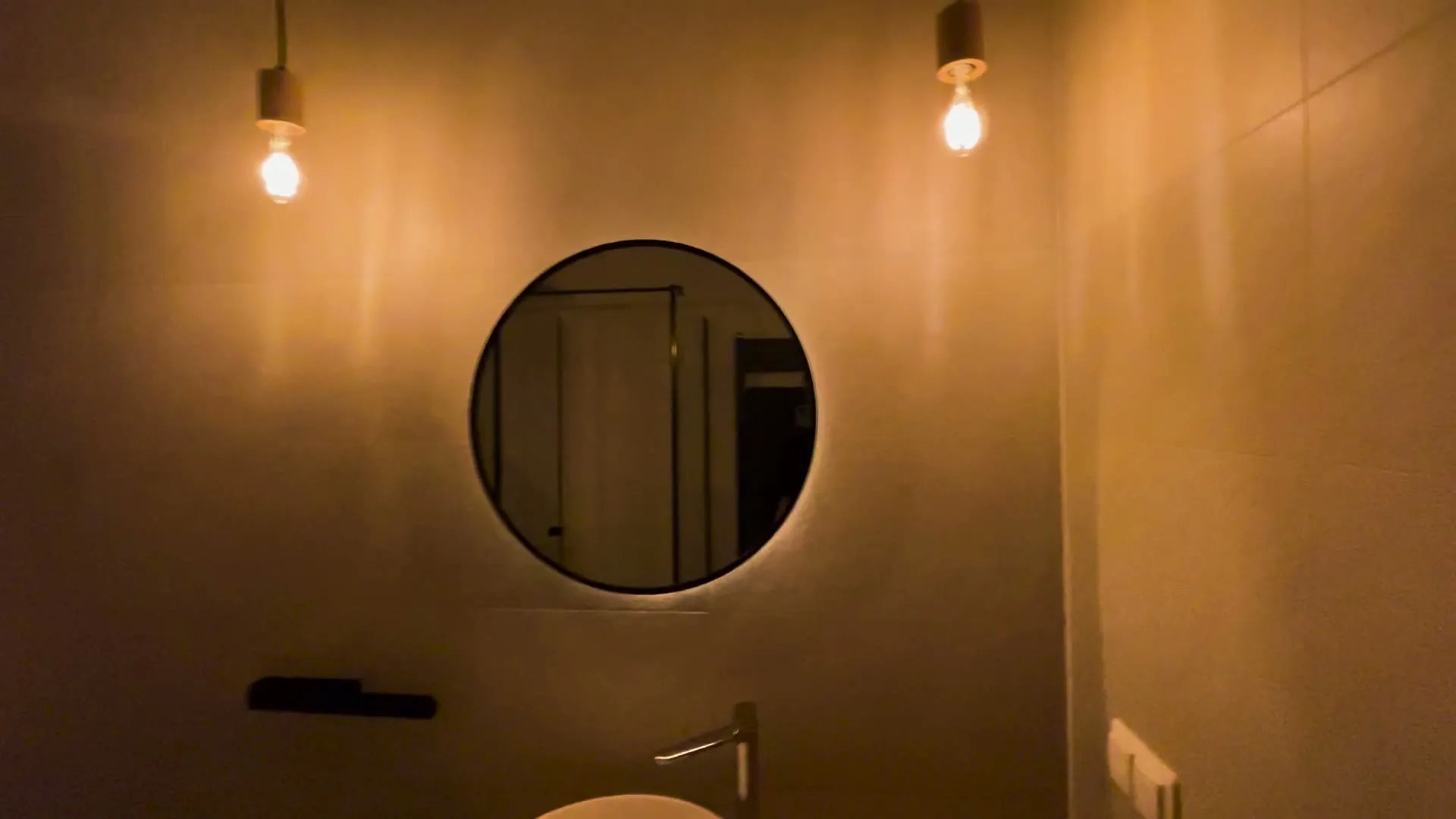 Teplé závěsné osvětlení nad zrcadlem