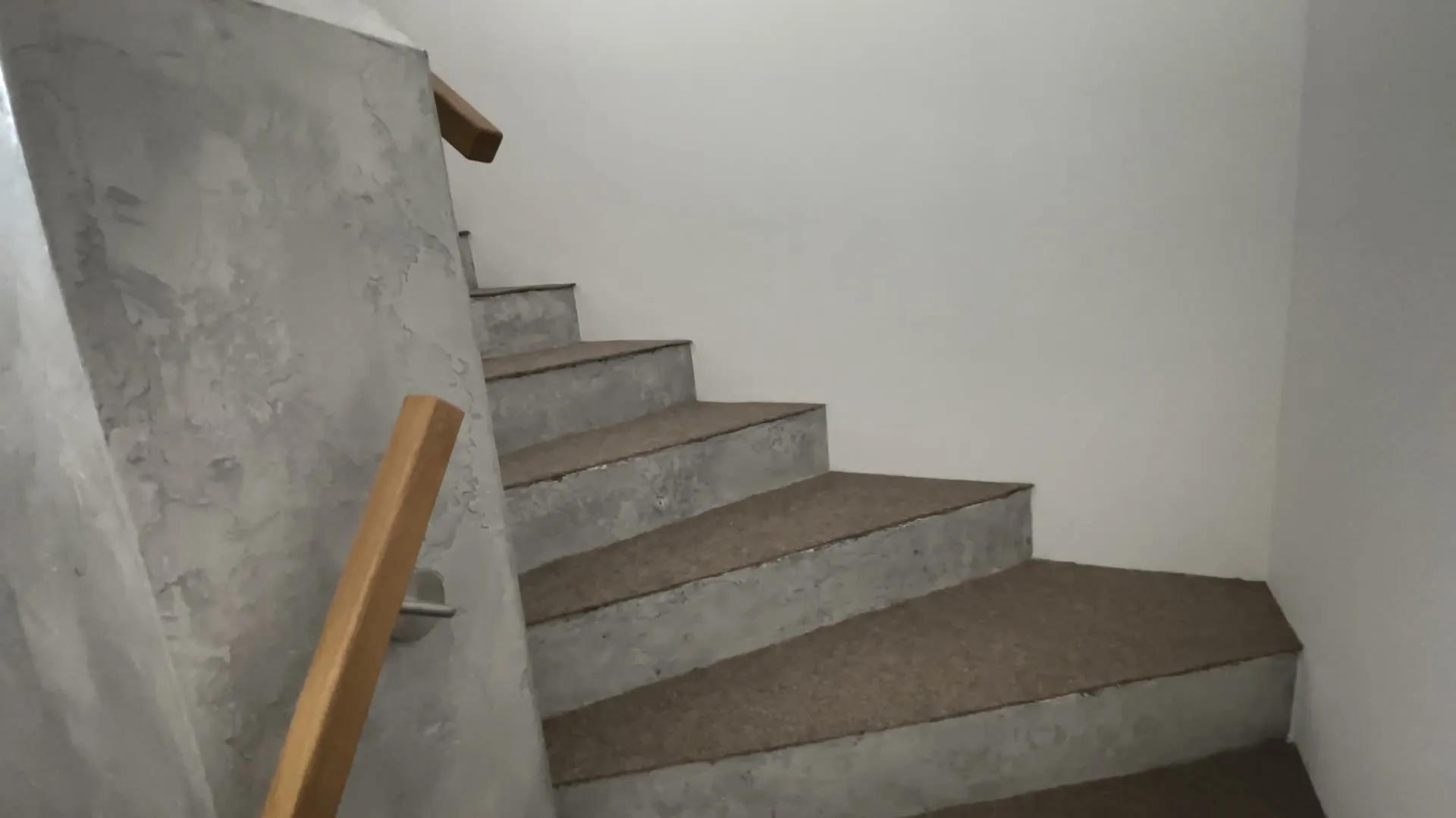 Betonová stěrka schodiště s dřevěným madlem