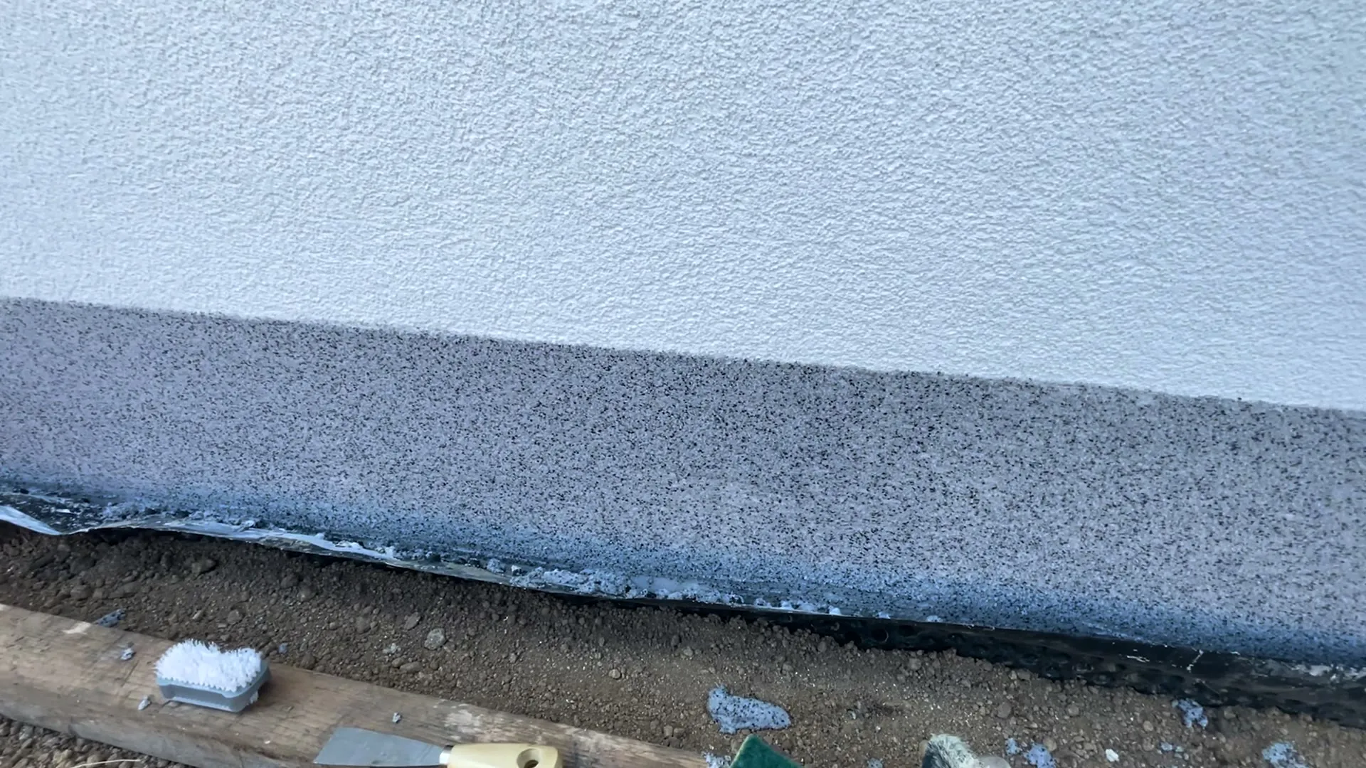Detail hrany první soklové omítky
