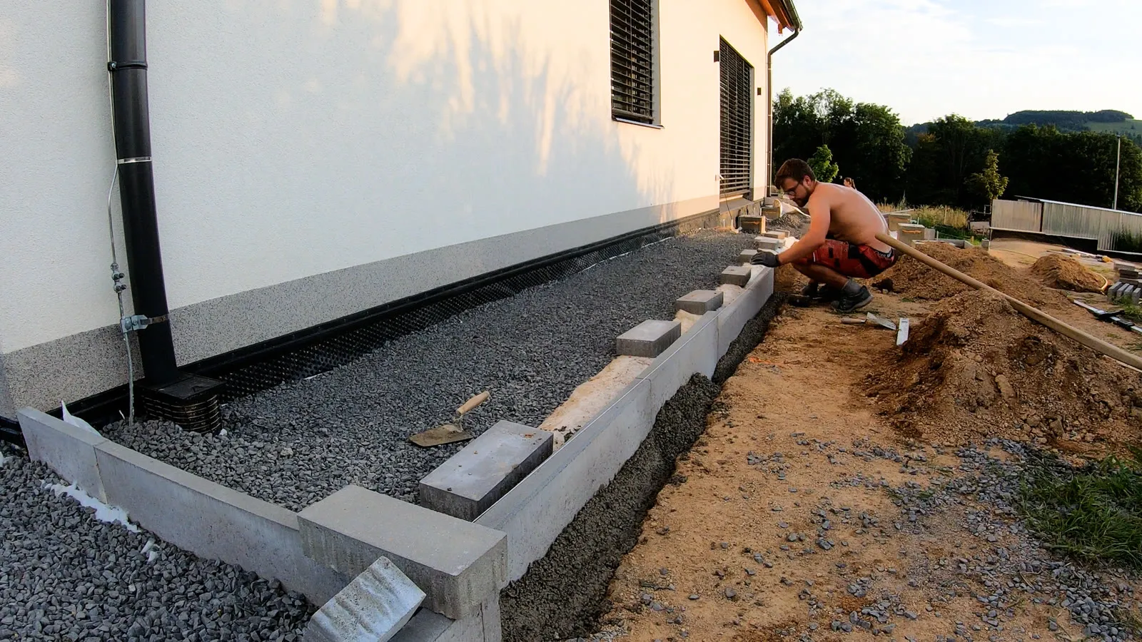 Betonové obrubníky u fasády na štěrku